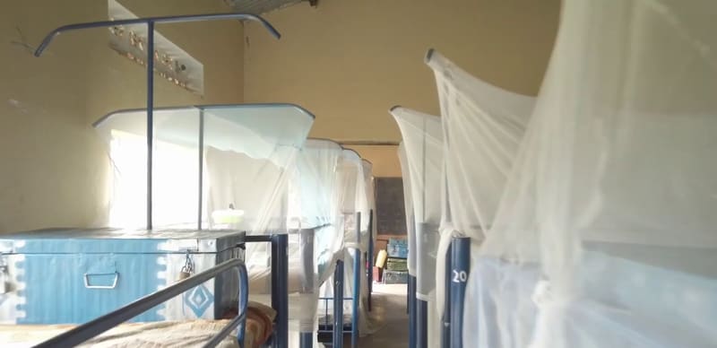 Metal bunk beds draped with mosquito nets in a Hadassah dormitory.